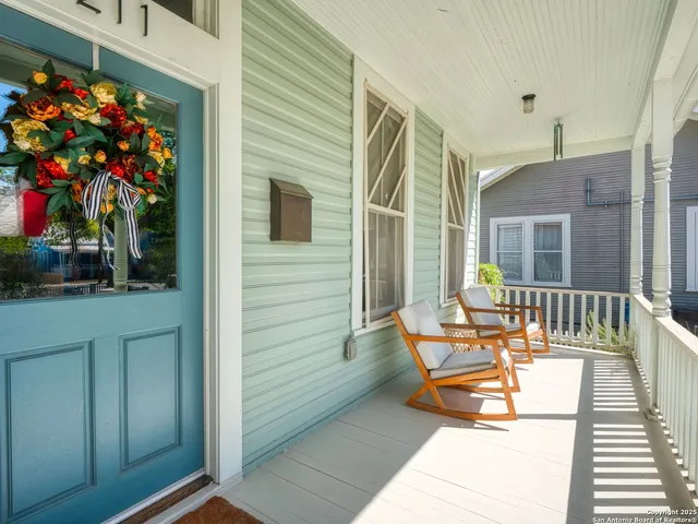 a balcony with dining table and chairs potted plants