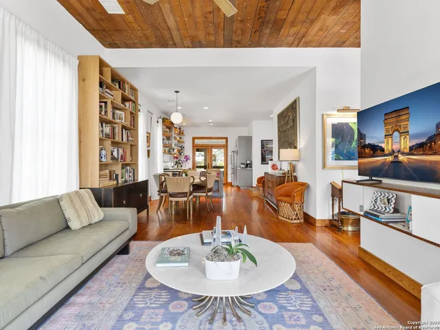 a living room with furniture kitchen view and a large window