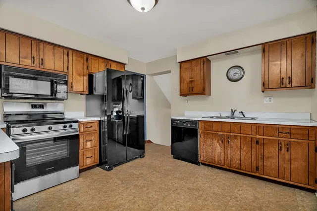 a kitchen with stainless steel appliances granite countertop a refrigerator stove and sink