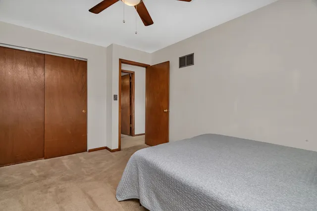 a bedroom with a bed and a chandelier fan