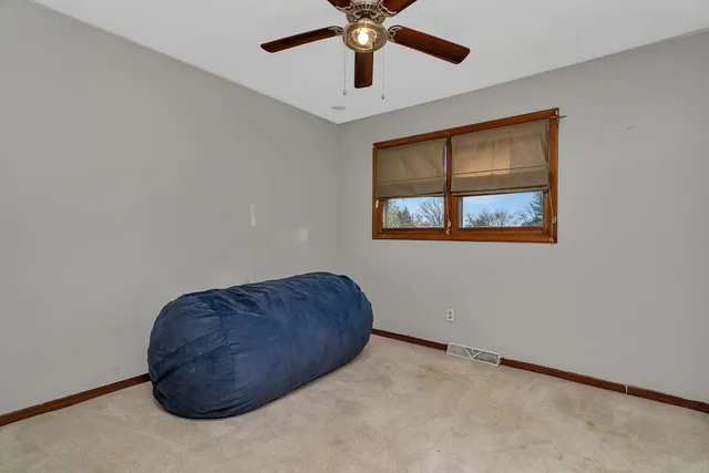 a view of a big room with windows and chandelier fan