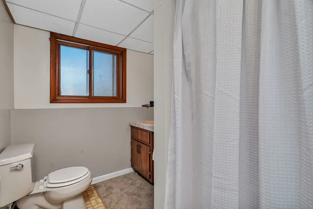 a bathroom with a toilet a sink and a mirror