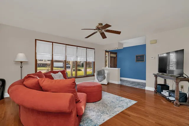 a living room with furniture a flat screen tv and a large window