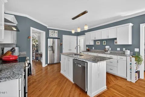 a kitchen with stainless steel appliances granite countertop a stove refrigerator and a sink