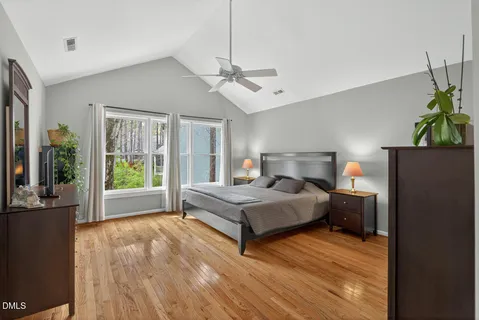 a bedroom with a bed lamps and wooden floor