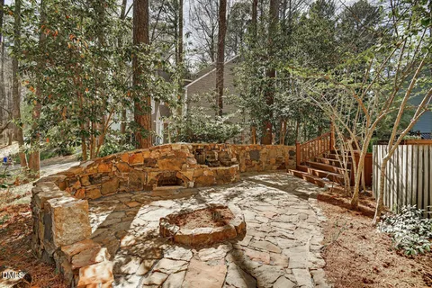 a view of a patio with table and chairs and wooden fence