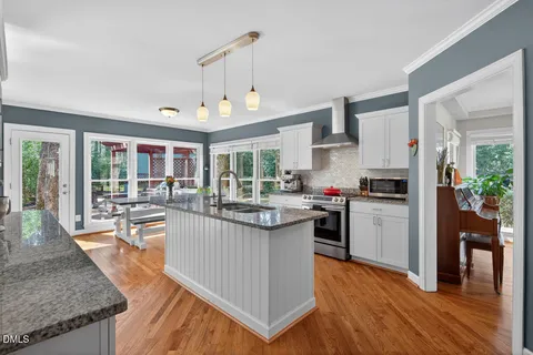 a kitchen with kitchen island granite countertop lots of counter top space and stainless steel appliances