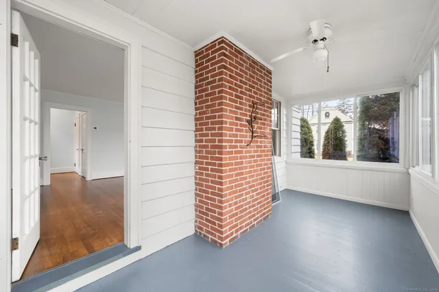 an empty room with wooden floor cabinet and windows