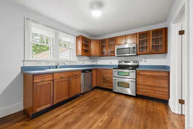 a kitchen with stainless steel appliances granite countertop a stove a sink and a microwave