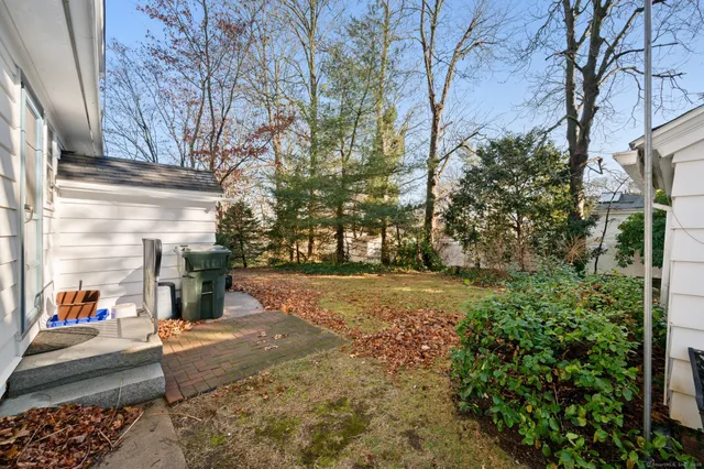 a view of a house with a yard and large tree