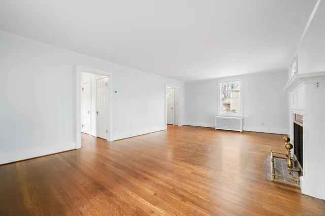 an empty room with wooden floor and fireplace