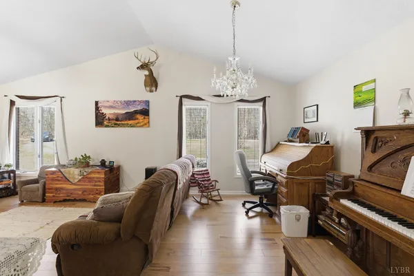 a kitchen with granite countertop a refrigerator a stove a dining table and chairs with wooden floor