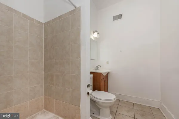 a white toilet sitting next to a shower
