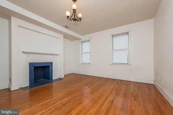 a view of empty room with wooden floor and fireplace