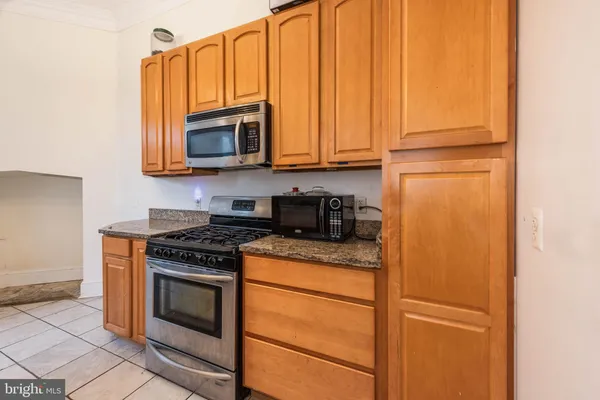 a kitchen with granite countertop cabinets stainless steel appliances and a counter space