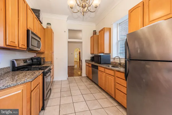a kitchen with stainless steel appliances granite countertop a refrigerator a stove and a sink