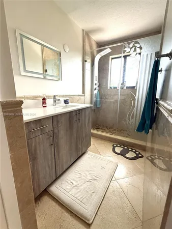 a bathroom with a sink mirror and vanity