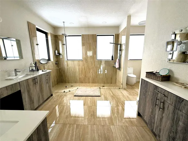 a bathroom with a sink a large mirror and shower