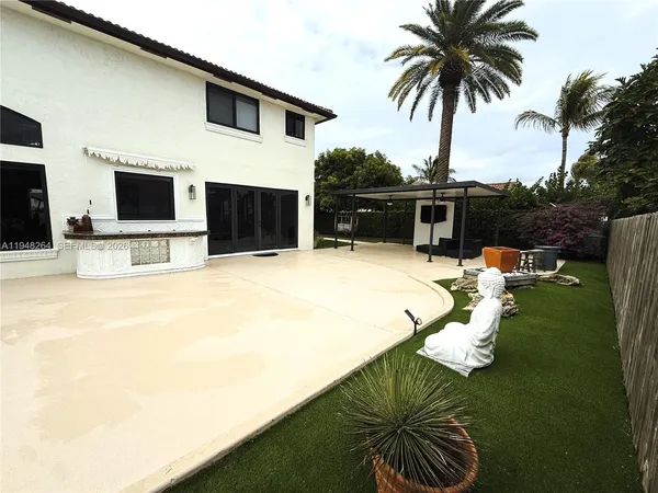 a swimming pool with outdoor seating and a garden