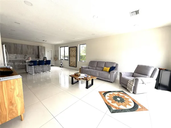 a living room with furniture and a dining table with kitchen view