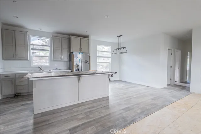 a kitchen with granite countertop a sink cabinets and wooden floor