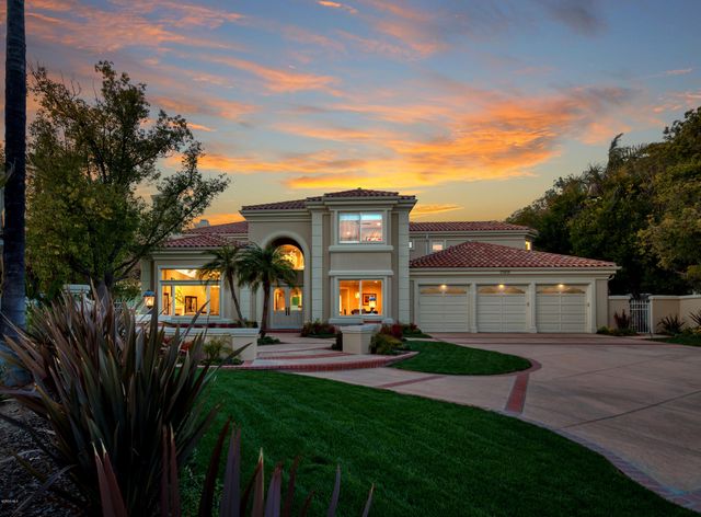 a front view of house with a garden and trees