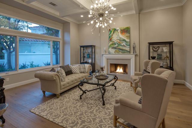 a living room with furniture a fireplace and a chandelier
