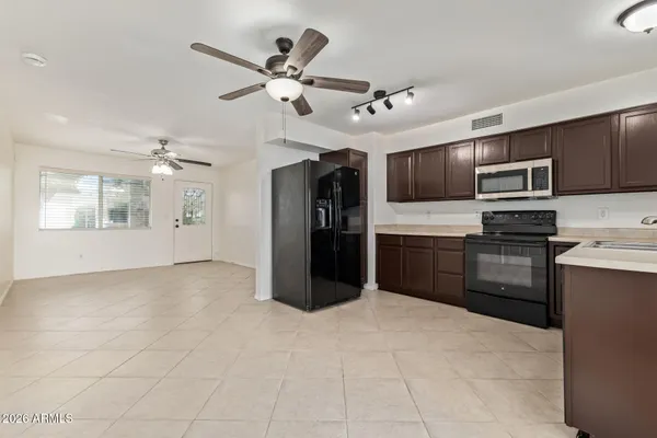 a kitchen with kitchen island granite countertop stainless steel appliances cabinets a sink and a window