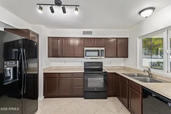 a kitchen with stainless steel appliances a sink stove and refrigerator