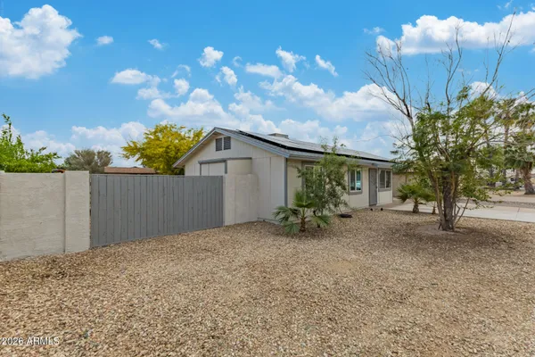 a view of a house with a backyard and tree