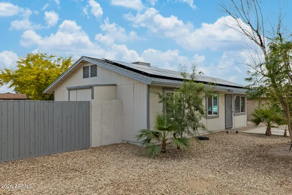 a backyard of a house with table and chairs with wooden fence