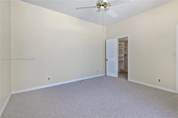 an empty room with chandelier fan