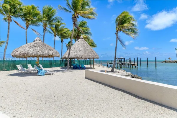 a view of a patio with a table and chairs under an umbrella