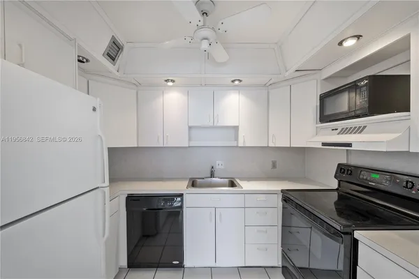 a kitchen with kitchen island granite countertop a sink stainless steel appliances and cabinets