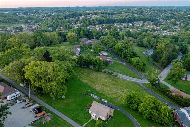 an aerial view of residential houses with outdoor space and trees