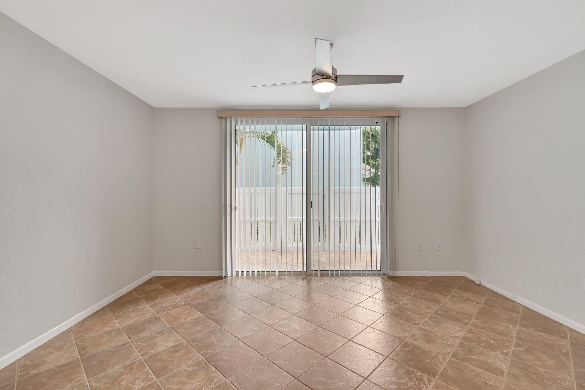 1016 Jeffery Street, Unit 1016 Boca Raton, FL 33487 - Photo 14 of 65 an empty room with chandelier fan and windows
