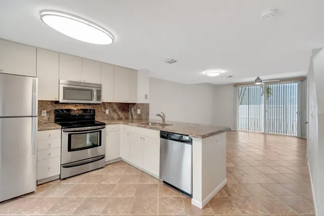 a kitchen with stainless steel appliances granite countertop a stove and a refrigerator
