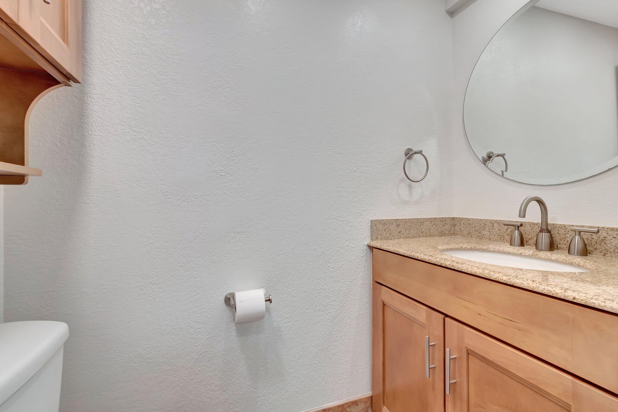 1016 Jeffery Street, Unit 1016 Boca Raton, FL 33487 - Photo 21 of 65 a bathroom with a granite countertop sink and a mirror