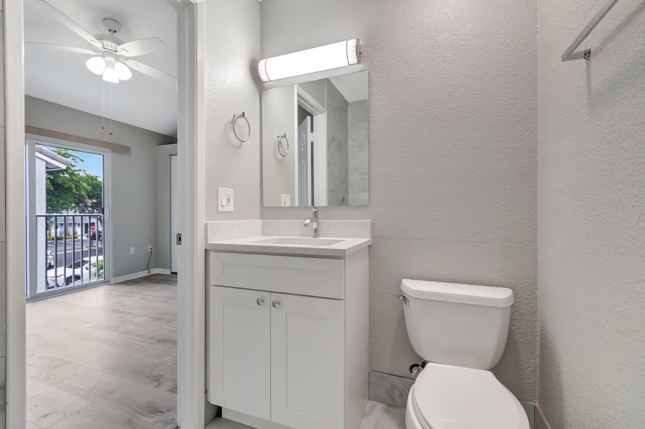 1016 Jeffery Street, Unit 1016 Boca Raton, FL 33487 - Photo 33 of 65 a bathroom with a toilet a sink and mirror