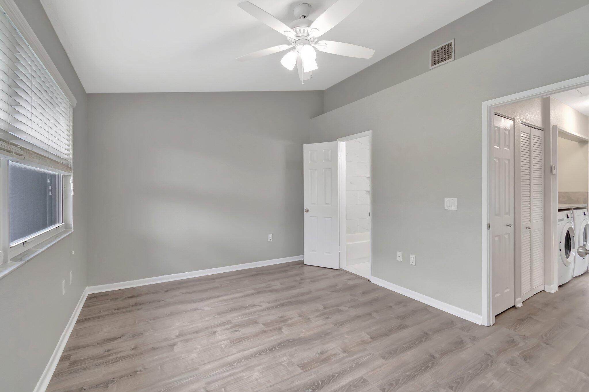 1016 Jeffery Street, Unit 1016 Boca Raton, FL 33487 - Photo 35 of 65 an empty room with wooden floor and windows