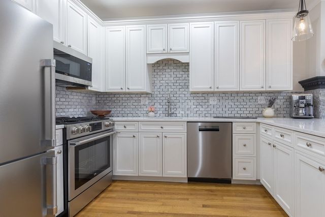 a kitchen with stainless steel appliances granite countertop a stove a sink and a microwave