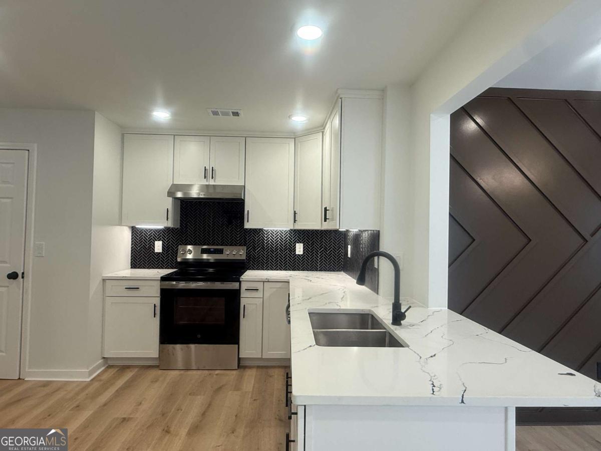 3112 North Avenue Decatur, GA 30033 - Photo 13 of 52 a kitchen with stainless steel appliances kitchen island granite countertop a sink a stove a refrigerator cabinets and a dining table