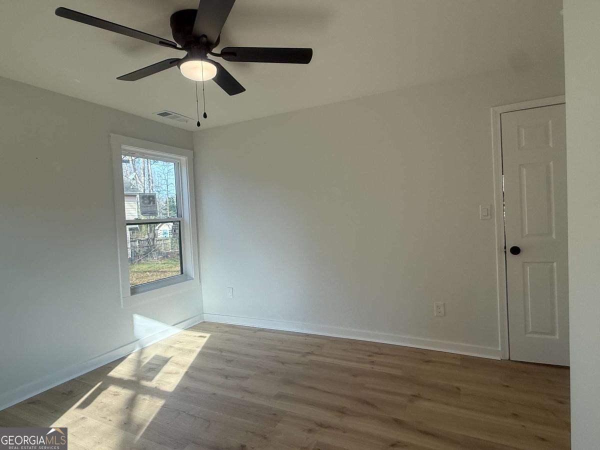 3112 North Avenue Decatur, GA 30033 - Photo 43 of 52 an empty room with wooden floor chandelier fan and windows