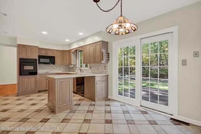 a view of kitchen with granite countertop cabinets and window