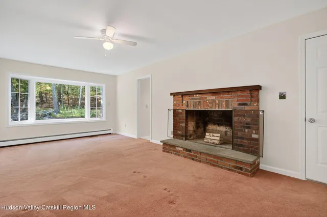 an empty room with fireplace and fan