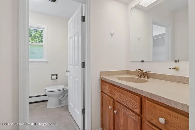 a bathroom with a granite countertop sink a toilet and a mirror