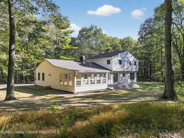 a front view of a house with a yard fountain and a tree