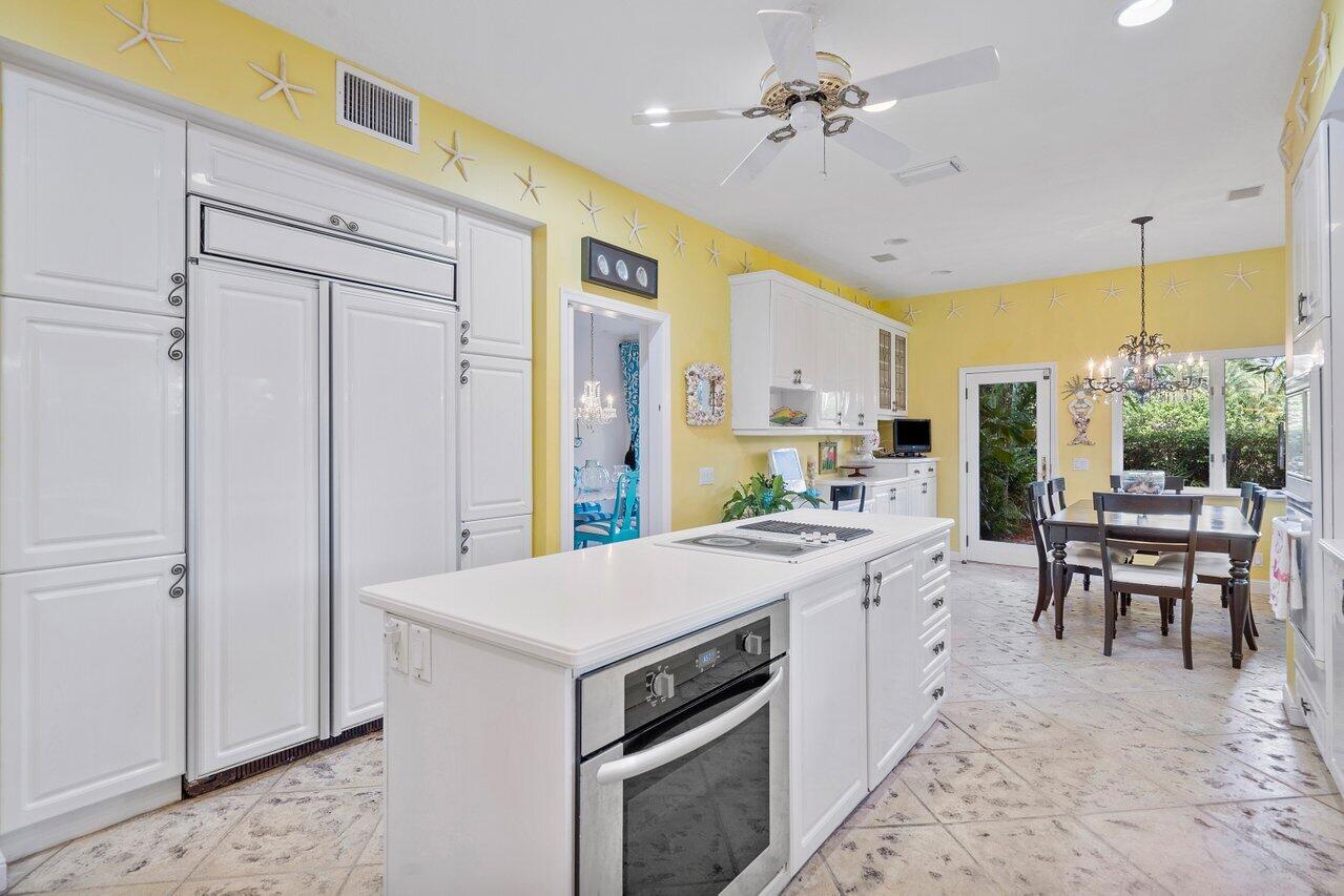 243 Florenada Terrace Boca Raton, FL 33486 - Photo 17 of 48 a kitchen with a stove a refrigerator a sink dishwasher with a dining table and chairs