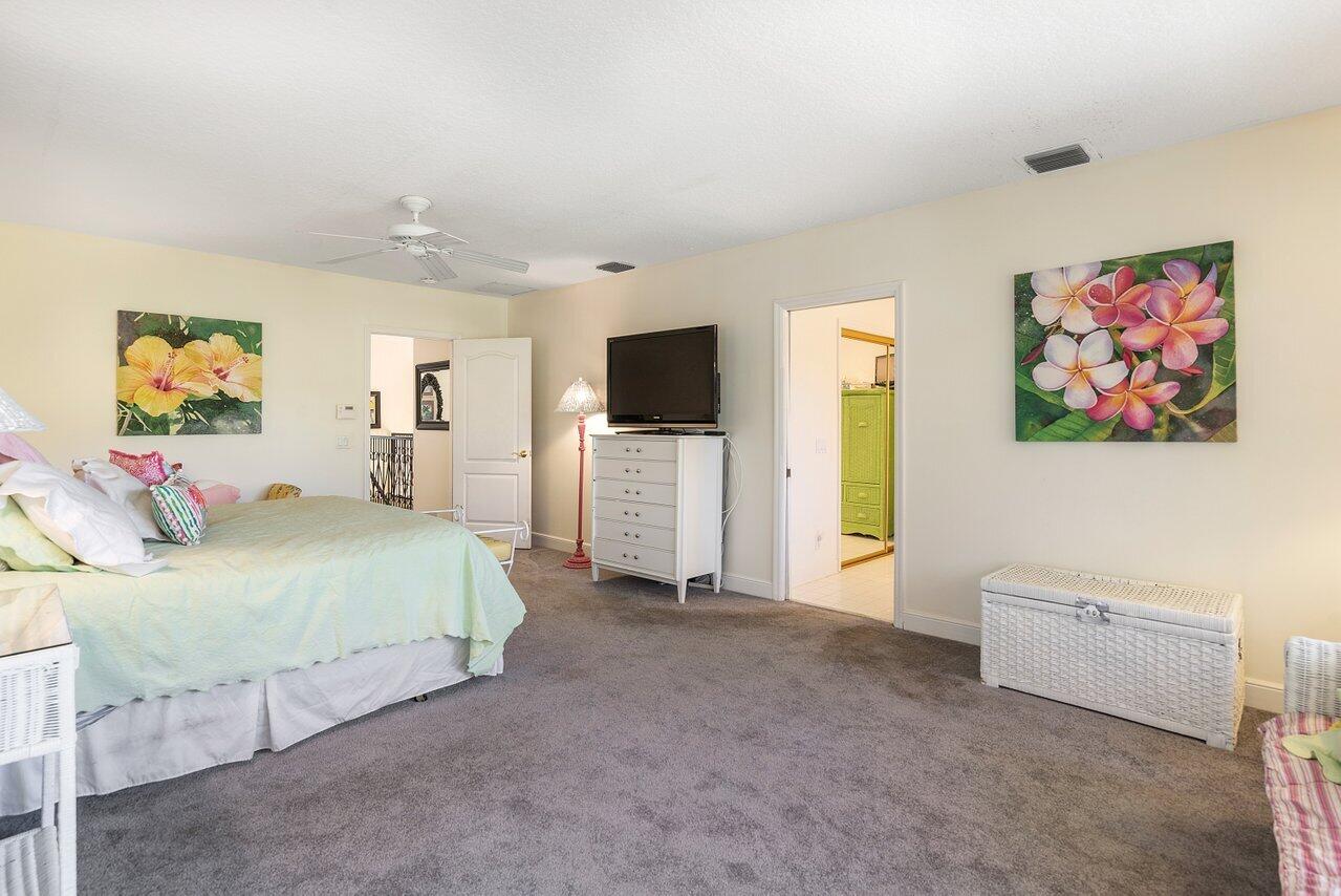 243 Florenada Terrace Boca Raton, FL 33486 - Photo 23 of 48 a spacious bedroom with a bed and a flat screen tv