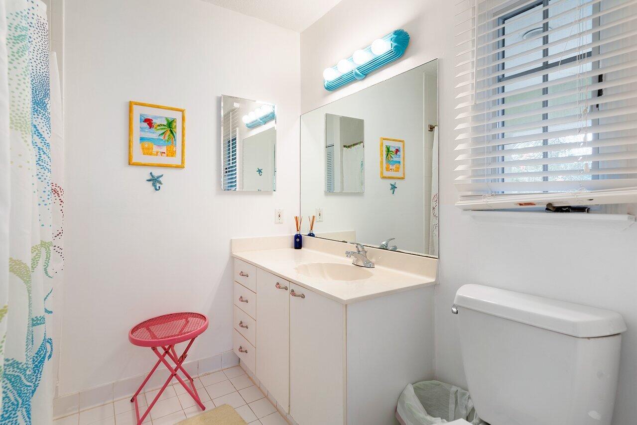 243 Florenada Terrace Boca Raton, FL 33486 - Photo 30 of 48 a bathroom with a toilet a sink and a mirror
